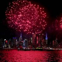 The tip of the Empire State Building is lit in blue as fireworks explode over the Hudson River celebrating the Lunar New Year on Thursday, as seen from Weehawken, New Jersey. Beijing tells officials not to set off New Year fireworks to curb smog