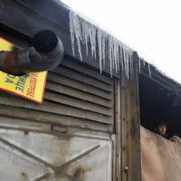 A migrant looks from inside an abandoned train car in Belgrade Wednesday. Hundreds of migrants are sleeping rough in parks and makeshift shelters in the Serbian capital in freezing temperatures waiting for a chance to move forward toward the European Union. | AP