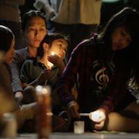 Yon Hui Bell holds her son, Emilio Rafael, during a vigil by community activists outside San Fernando Cathedral in San Antonio, Texas, on Thursday, the eve of Donald Trump\'s inauguration as president. The group gathered to show their support for immigrants, women, minorities and others they fear may be harmed by the new administration\'s policies. | AP