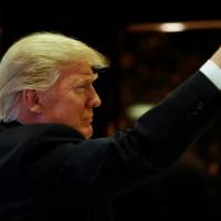 U.S.President-elect Donald Trump gestures to people in the lobby after speaking to the press at Trump Tower in New York on Friday. | REUTERS