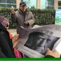A Chinese man holds up a newspaper with a front page photo of U.S. President-elect Donald Trump and a headline that reads \"Outsider counterattack\" in Beijing on Nov. 10. | AP