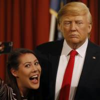 Madame Tussauds’ employee Helen Smith takes a selfie next to the wax figure of President-elect Donald Trump, as they unveil the figure just days ahead of the American’s Presidential Inauguration in Washington in London Wednesday. The figure will now reside in Madame Tussauds’ London Oval Office alongside fellow famous politicians and global icons also immortalized in wax. Madame Tussauds unveils wax figure of Trump