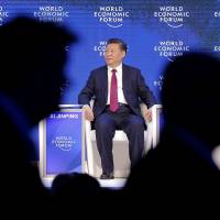 Chinese President Xi Jinping sits on the podium while people leave Tuesday at the World Economic Forum in Davos, Switzerland. | AP