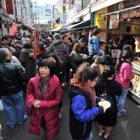The shops and food stalls in the Tsukiji outer market are packed with tourists on Jan. 19. | YOSHIAKI MIURA