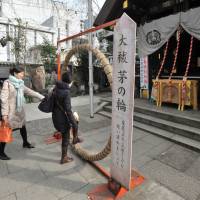 Visitors to Namiyoke Inari Shrine in Tsukiji, Tokyo, pass through a hoop made of grass that is believed to purify their spirits. | YOSHIAKI MIURA