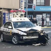 A police car sits on a street in Tokyo\'s Koto Ward on Wednesday, after it was involved in a collision with a truck being pursued during a chase. | KYODO