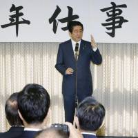 Prime Minister Shinzo Abe delivers New Year greetings to LDP members at party headquarters in Tokyo on Wednesday. | KYODO