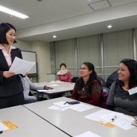 Foreign volunteers hone their translation skills in a class taught by a professional interpreter in Itabashi Ward, Tokyo, on Saturday &#8212; the latest in a series of workshops organized by the Asian People\'s Friendship Society. | TOMOHIRO OSAKI