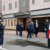 Police examine a street in front of a hotel in the city of Fukuoka on Wednesday after a man jumped to his death from a room on the seventh floor. | KYODO