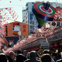 People visit Sensoji Temple in Tokyo’s Asakusa district on Sunday. A new year, a new prayer, and hopefully luck