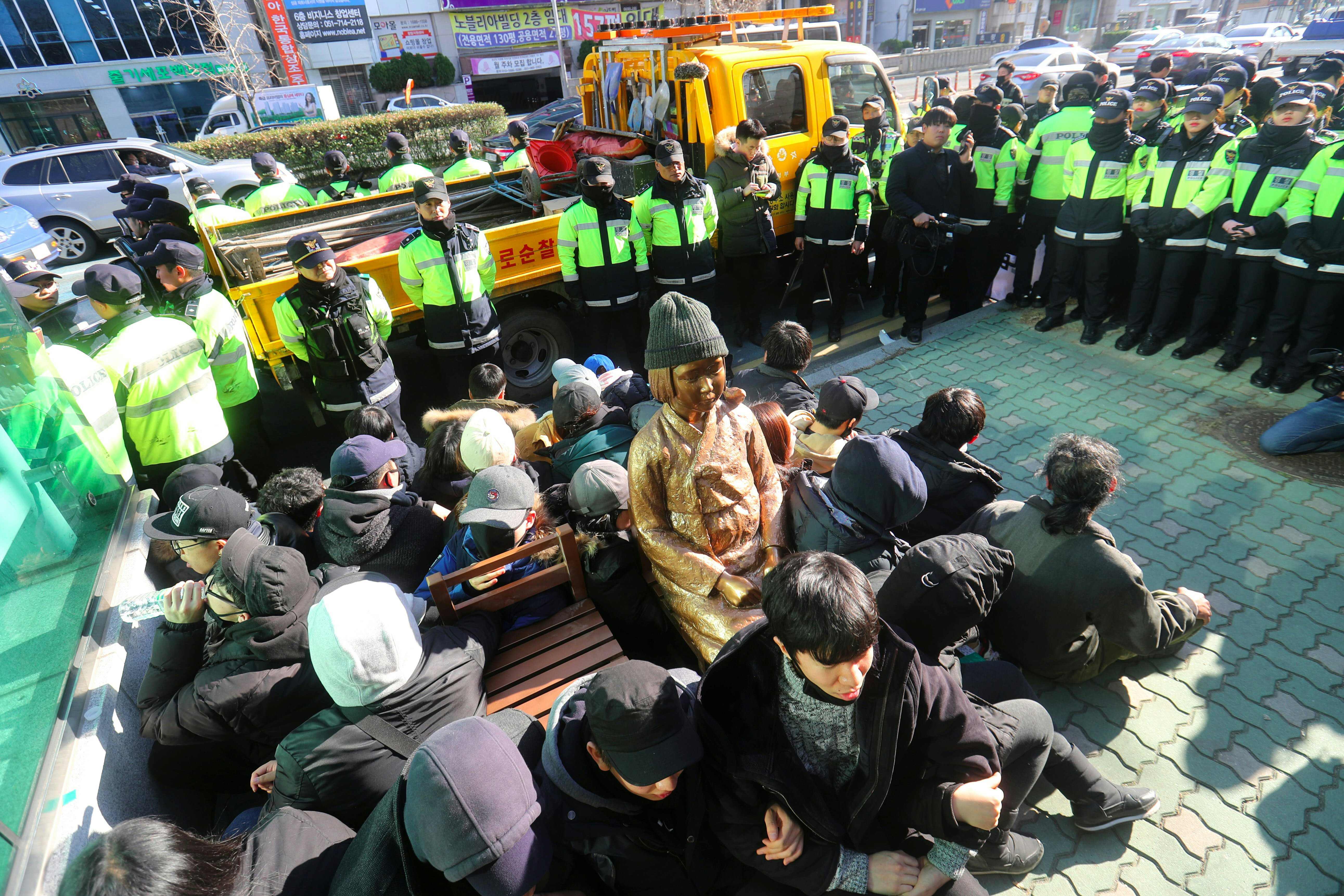 This picture taken on Dec. 28, 2016, shows South Korean activists staging a sit-in protest around a statue in Busan of a teenage girl symbolizing former 'comfort women' who served as sex slaves for Japanese soldiers during World War II. | AFP-JIJI