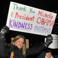 A participant in the Friday march in Tokyo holds up a sign to express gratitude to outgoing U.S. President Barack Obama. | YOSHIAKI MIURA