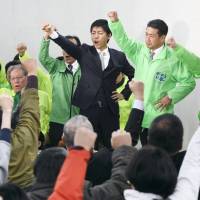 Hiroto Fujii (center), the former mayor of the city of Minokamo in Gifu Prefecture, who stepped down after being convicted of bribery in December, celebrates ahead of his expected victory in a mayoral election held Sunday. | KYODO