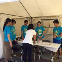 Members of student volunteer group Team Medics provide medical help at the Global Festa Japan event in October 2015. | COURTESY OF TEAM MEDICS