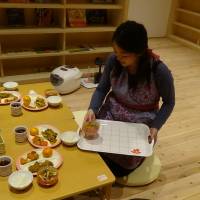 A member of the Nippon Foundation\'s after-school facility for elementary school children in Toda, Saitama Prefecture, serves a meal for children. | COURTESY OF LEARNING FOR ALL