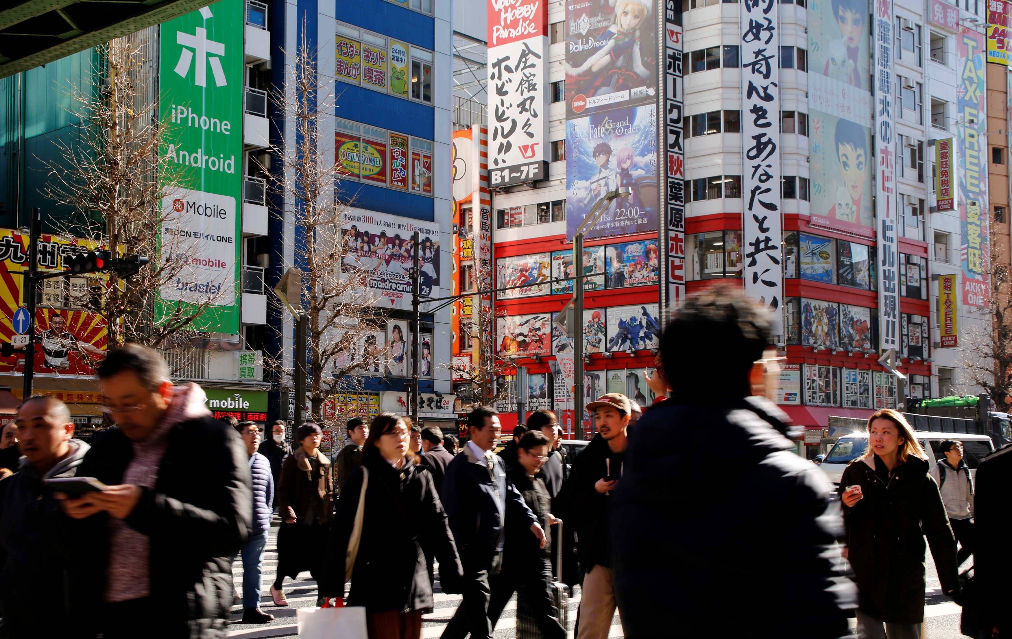 People cross a street in the Akihabara shopping district in Tokyo on Tuesday. The 22 percent increase in the number of international visitors to Japan from the year before is smaller than the 48 percent surge logged in 2015. | REUTERS