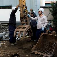 Kurdish men work at a demolition site in Chiba Prefecture on Oct. 21, 2015. | REUTERS