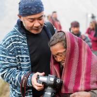 Checking the shot: Bon Ishikawa shows a Nepalese woman one of his pictures. | REI MIYAMOTO