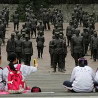 Students sit at the Chinese Heroes Statues Plaza, which displays war heroes from the War of Resistance against Japan, in Jianchuan Museum Cluster in Anren, Sichuan Province. Media deployed to fight history wars in East Asia
