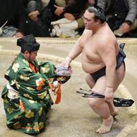 Kisenosato (right) is seen after beating Ichinojo on Saturday, the 14th day of the New Year Grand Sumo Tournament at Ryogoku Kokugikan. Kisenosato (13-1) secured his first career title with the win over Ichinojo. | KYODO
