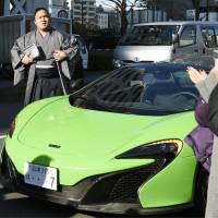 Maegashira Ishiura arrives at Ryogoku Kokugikan in a McLaren sports car on Tuesday, for the third day of the 15-day New Year Grand Sumo Tournament. The car was provided by his new sponsor, McLaren Automotive, to mark his 27th birthday. | KYODO
