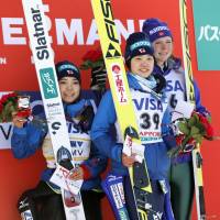 Winner Yuki Ito (center) stands with runner-up Sara Takanashi (left) and third-place finisher Maren Lundby after a World Cup ski jumping event in Sapporo on Saturday. | KYODO