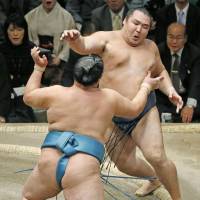 Kakuryu (top) backpedals during his defeat to Tamawashi at the New Year Grand Sumo Tournament on Tuesday. | KYODO
