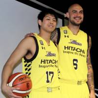 Robert Sacre stands with Tsukuba University’s Yusei Sugiura, who is joining the Sunrockers as a special assigned player, on Thursday in Shibuya. | KAZ NAGATSUKA