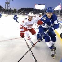 Maple Leafs center William Nylander (right) and the Red Wings’ Gustav Nyquist chase the puck during the NHL Centennial Classic on Sunday in Toronto. Maple Leafs edge Red Wings in Centennial Classic