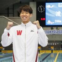 Ippei Watanabe poses in front of the scoreboard after breaking the 200-meter breaststroke world record on Sunday in a time of 2 minutes, 6.67 seconds. Watanabe breaks 200-meter breaststroke world record
