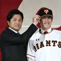 Daikan Yoh (right) poses for photos with Giants manager Yoshinobu Takahashi during his introductory news conference on Dec. 19. | KYODO