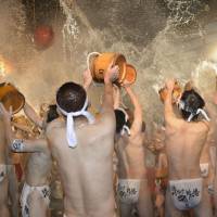 Men wearing loincloths pour hot water over each other in a traditional festival to pray for good health at a hot spring in Naganohara, Gunma Prefecture, on Friday. They dedicated a chicken to thank the god of hot springs during the event, which the organizer says originated some 400 years ago. | KYODO
