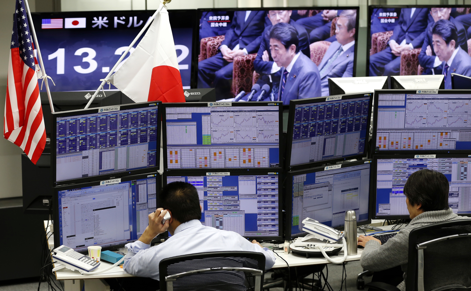 Money traders operate at a foreign exchange brokerage in Tokyo Wednesday. Japanese officials rejected U.S. President Donald Trump's claim that Tokyo is seeking to weaken the yen against the dollar to gain a trade advantage. | AP