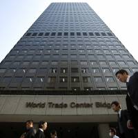 Pedestrians walk past the World Trade Center Building, which houses the Orix Corp. headquarters, in Tokyo’s Minato Ward. Orix offers cash incentive to get workers to take five straight days of paid leave