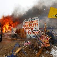 A structure burns after being set alight by protesters preparing to evacuate the main opposition camp against the Dakota Access oil pipeline near Cannon Ball, North Dakota, Wednesday. | REUTERS