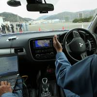 Mitsubishi Electric Corp. engineers demonstrate the company\'s self-driving technology on a test course in Hyogo Prefecture last March. | BLOOMBERG