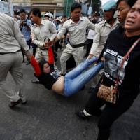 Cambodians demonstrating in support of land rights activist Tep Vanny are detained outside the Phnom Penh Municipal Court on Thursday. | REUTERS