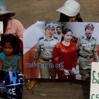 Protesters hold an image of land-rights activist Tep Vanny outside the courthouse during her trial on Thursday. | REUTERS