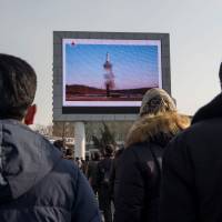 People in Pyongyang watch a public broadcast on Feb. 13 about the launch of a surface-to-surface medium long-range Pukguksong-2 ballistic missile last week. | AFP-JIJI