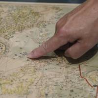 A man points to what is now known as the Spratly Islands in the South China Sea on a Japanese World War II-era map purporting to support China\'s claims to vast parts of the South China Sea. | AP