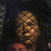 Guadalupe Garcia de Rayos is locked in a van that is stopped in the street by protesters outside the Immigration and Customs Enforcement facility Wednesday in Phoenix, Arizona. Apparently fearing her deportation, activists blocked the gates surrounding the office near central Phoenix in what the Arizona Republic says was an effort to block several vans and a bus inside from leaving. | ROB SCHUMACHER / THE ARIZONA REPUBLIC VIA AP