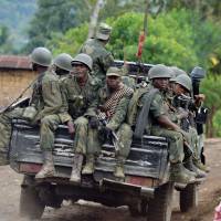 Armed Forces of the Democratic Republic of Congo (FARDC) soldiers ride in the back of a pick-up truck in 2013 near the Mbuzi hilltop by Rutshuru. Democratic Republic of Congo snubs calls for massacre video investigation