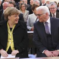 Frank-Walter Steinmeier and German Chancellor Angela Merkel attend mass at St. Hedwigs Cathedral in Berlin on Sunday ahead of his election as Germany\'s new president. | AP
