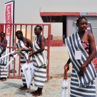 Hostesses stand outside a movie theater that runs on solar power during its inauguration in Ouagadougou on Friday, the eve of the opening of the Pan-African Film and Television Festival. Solar-powered movie theater opens in Burkina Faso ahead of film festival