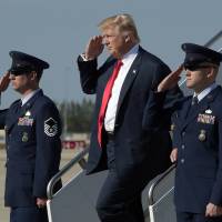 U.S. President Donald Trump salutes as he arrives at Palm Beach International Airport in West Palm Beach, Florida, on Friday. With Florida rally, Trump looks to bypass media as campaigner-in-chief