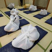 Participants perform \"otonamaki\" (adult wrapping) at a session in Asaka, Saitama Prefecture on Feb. 4. | REUTERS