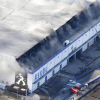 Smoke rises from a warehouse of online office supply vender ASKUL Corp. in Miyoshi, Saitama Prefecture, on Sunday. | KYODO