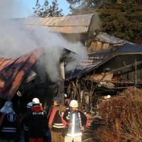 Smoke rises from a house that burned down in Tono, Iwate Prefecture, on Tuesday. | KYODO