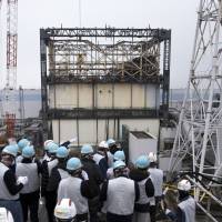 Members of the media take in the No. 1 reactor at the Fukushima No. 1 power plant in Fukushima Prefecture on Thursday. | AP