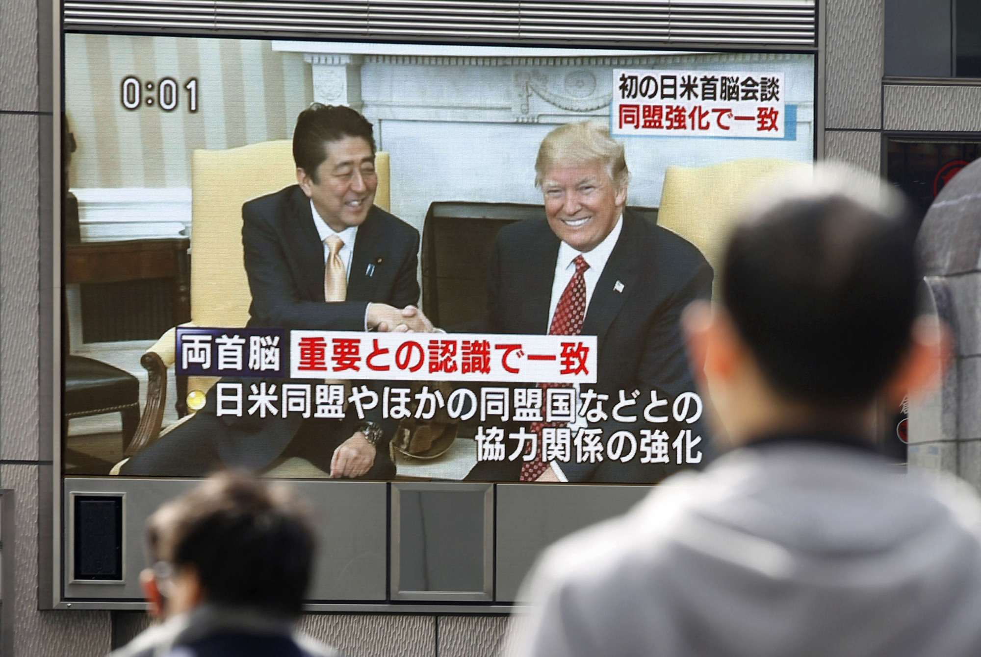 A big screen set up in the Dotonbori shopping district in the city of Osaka shows the meeting Saturday between Prime Minister Shinzo Abe and U.S. President Donald Trump. | KYODO